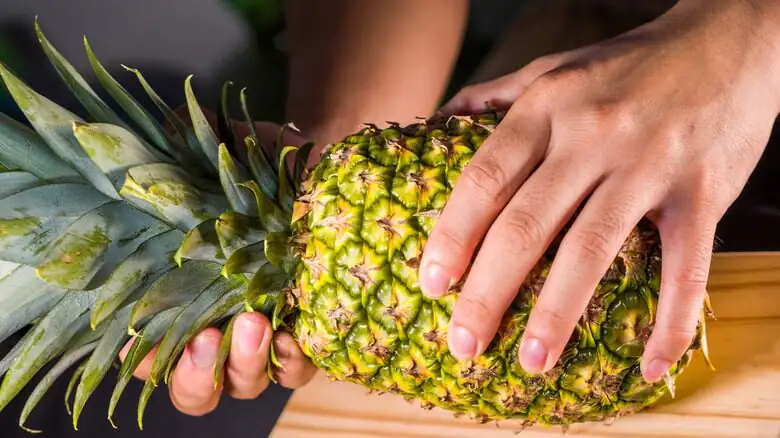 hands twisting pineapple crown