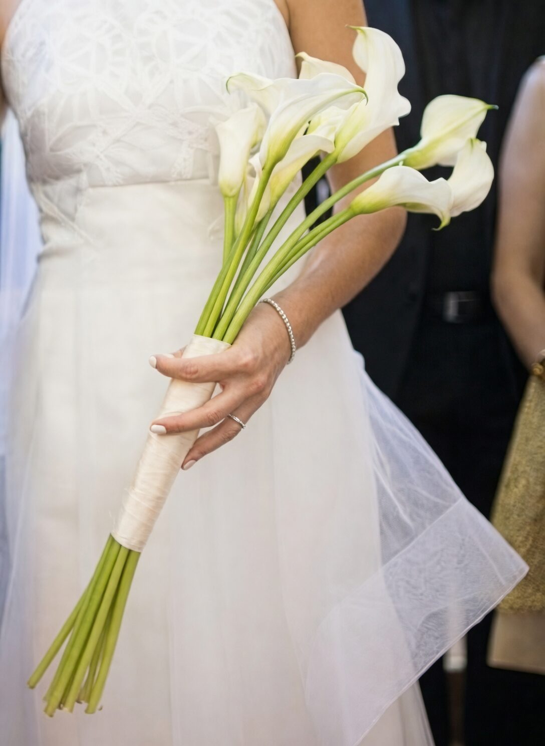 bride holding white calla lily bouquet